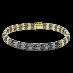 This stunning bracelet is wrought from 14k gold and titanium, and features .74 ctw of black diamonds set into its zigzag pattern.